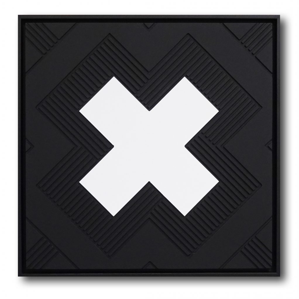 The letter X carved in wood, then painted in black and white