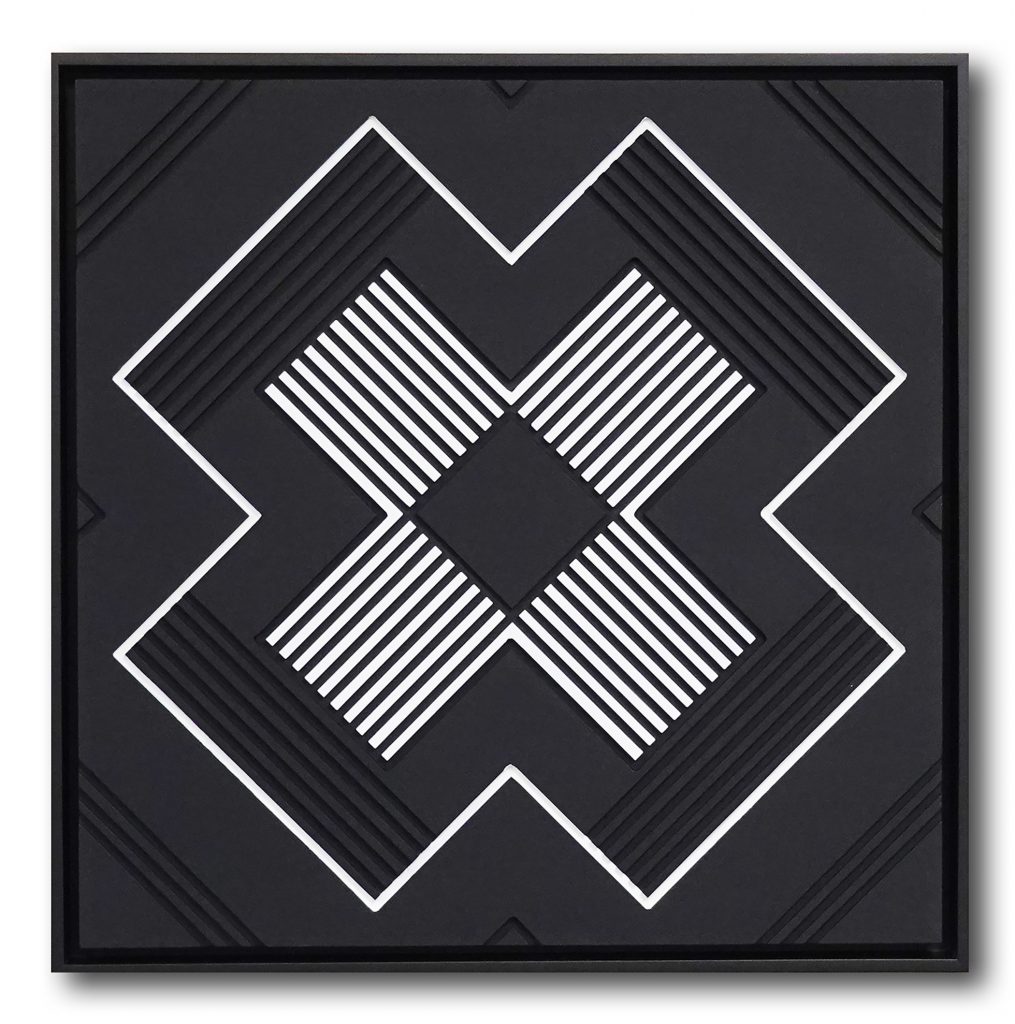 The letter X, carved in wood, then painted in whites and blacks